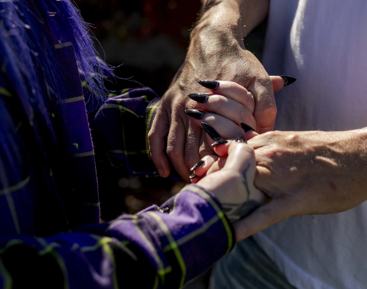 Randee Noggle and her husband, Adam hold hands at her home in Taylor, Mich. on June 30, 2024. The family fell on hard times when his income working in the restaurant industry dropped during the pandemic. That’s when Noggle found EasyKnock.