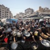 GAZA CITY, GAZA - JULY 23: Palestinians carrying pans, gather to receive hot meals, distributed by a charity organization in Gaza City, where residents are struggling to access food due to the ongoing Israeli blockade and attacks in Gaza City, Gaza on July 23, 2025.