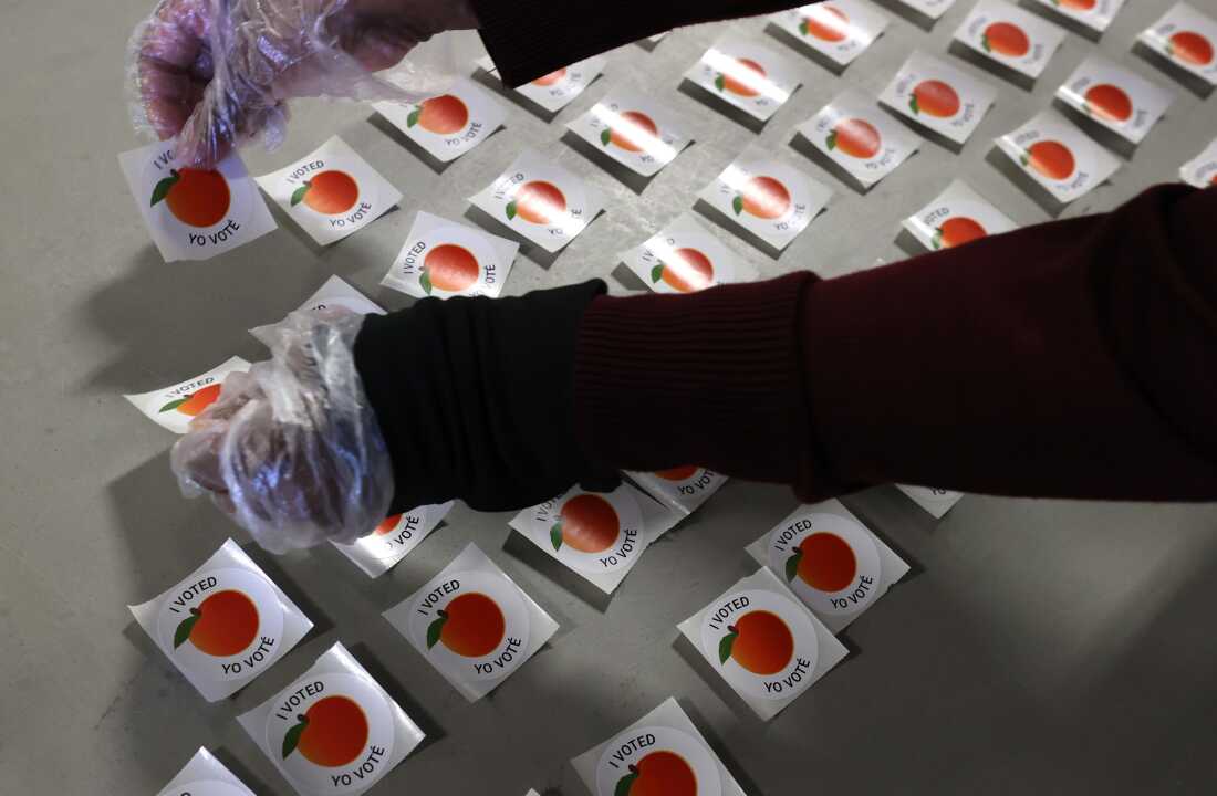 A poll worker lays out 'I voted' stickers at the Gwinnett County Fairgrounds on October 30, 2020 in Lawrenceville, Georgia.