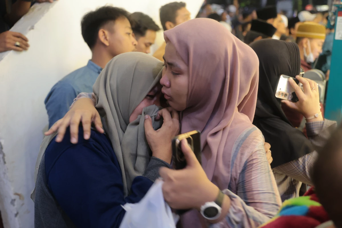 A woman is comforted as she weeps while rescue work is underway after a building collapsed at an Islamic boarding school in Sidoarjo, East Java, Indonesia, on Sept. 29, 2025.
