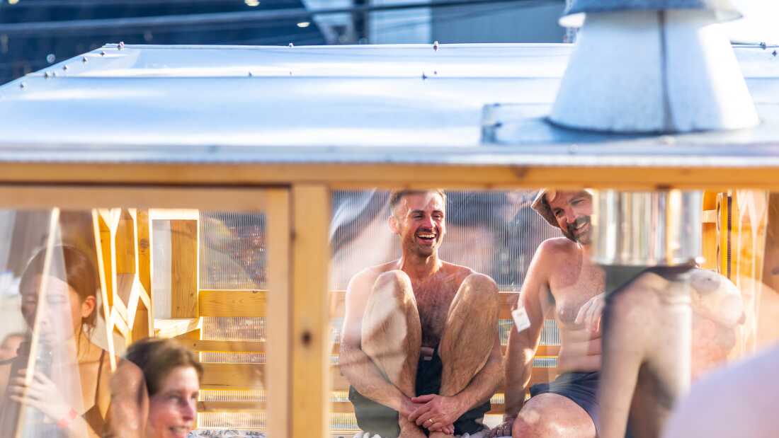 Sauna enthusiast Michael Calcagno, second from right, sits inside a clear-walled wood-fired sauna during the Seattle Sauna Festival in November. Sauna use has taken off as a health practice and scientists are studying its benefits.