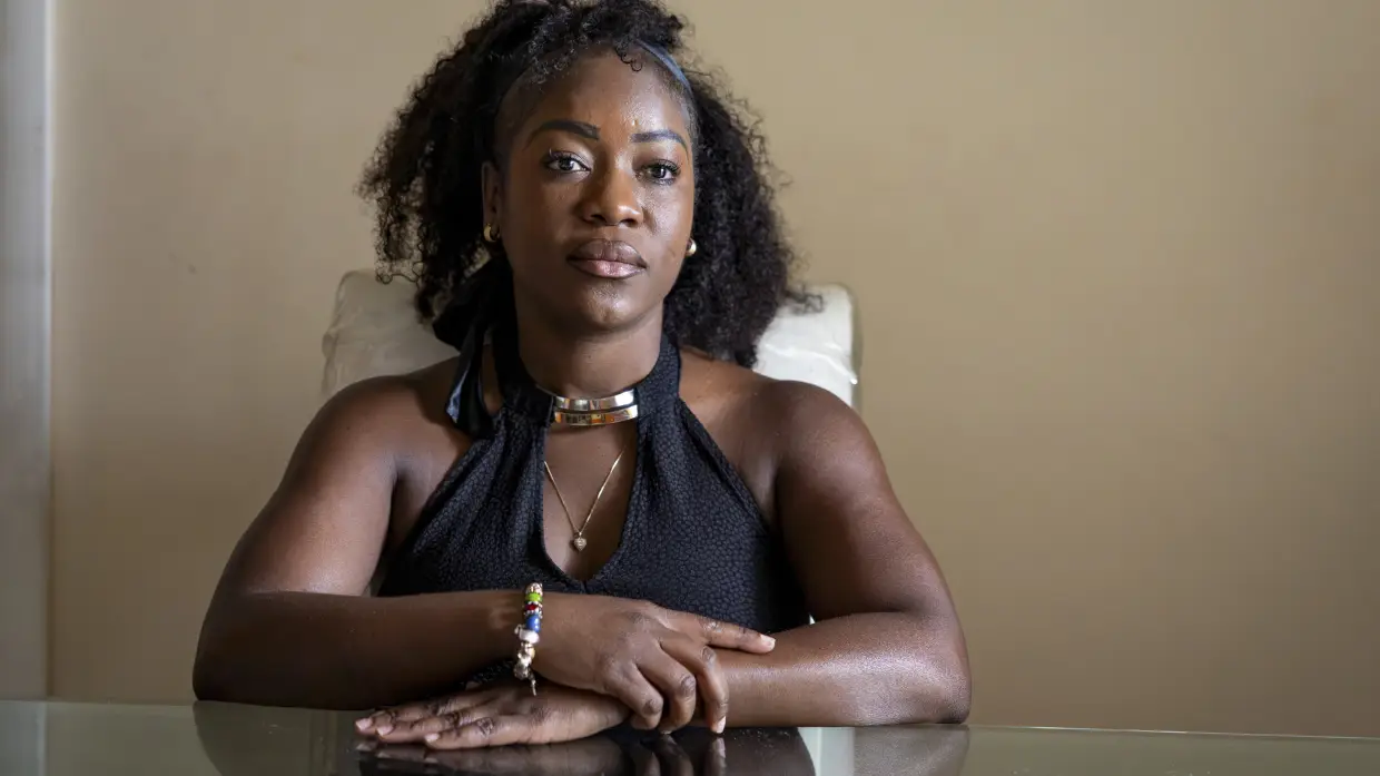 Herlain, who asked NPR to withhold her last name, poses for a portrait at her home in North Lauderdale, Fla. She is a registered nurse from Haiti who recently lost her temporary protected status, or TPS.