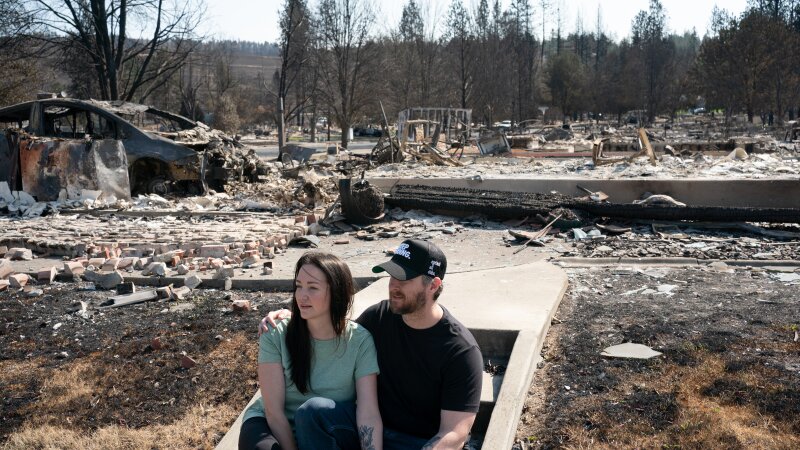 Image 30: Melissa and Christopher Matthews in front of the remains of their home in Spokane on August 14, 2026. The Spokane Complex fires have caused over 900 structures to burn down.