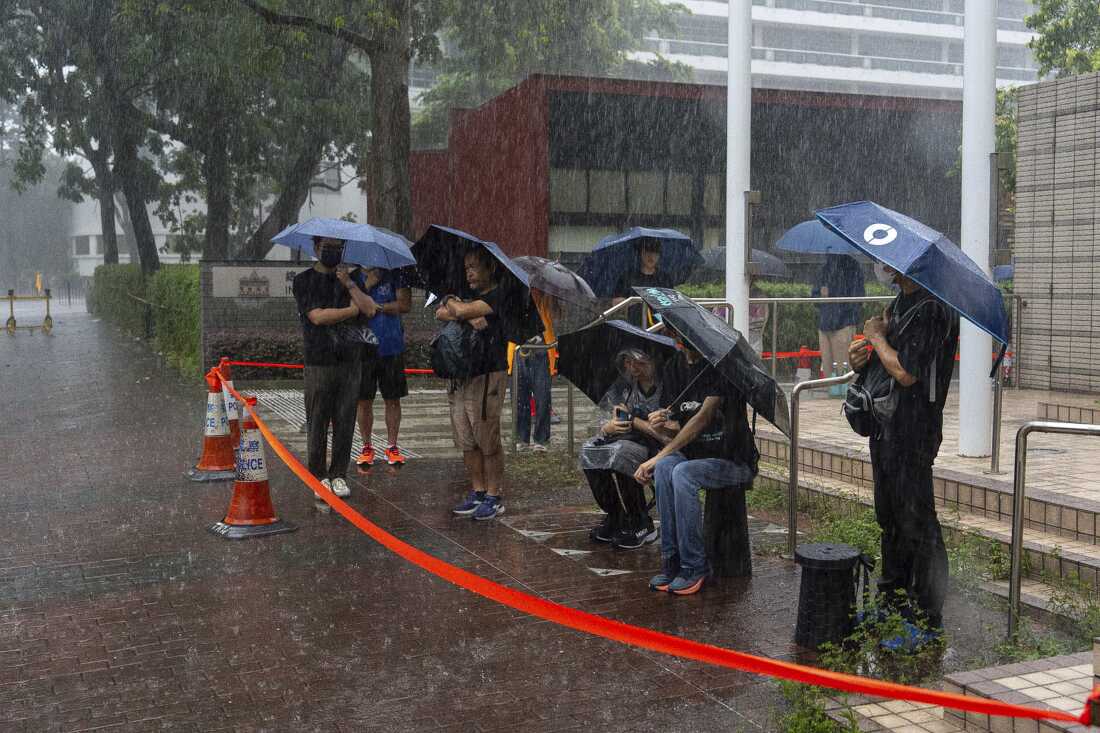 People wait to enter the West Kowloon Magistrates' Courts ahead of the closing statements for Hong Kong activist publisher Jimmy Lai's national security trial in Hong Kong, Thursday, Aug. 14, 2025. (AP Photo/Chan Long Hei)