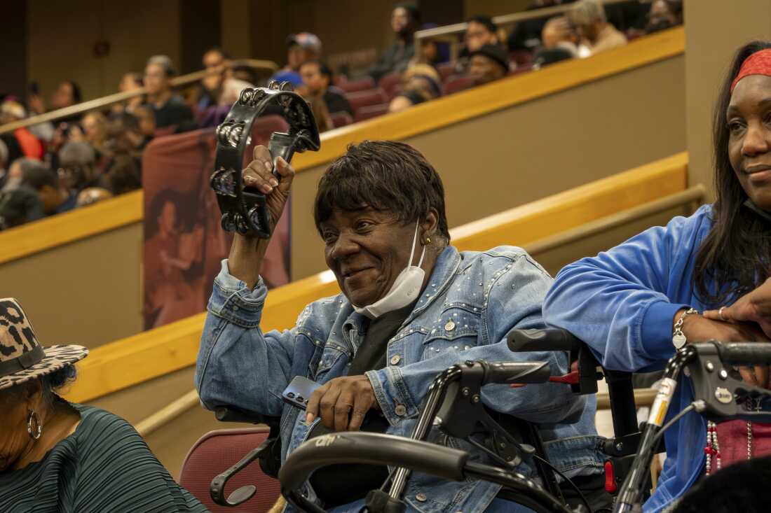 An attendee raises a tambourine during a musical tribute at a public homegoing service for the Rev. Jesse Jackson at the House of Hope on Friday.