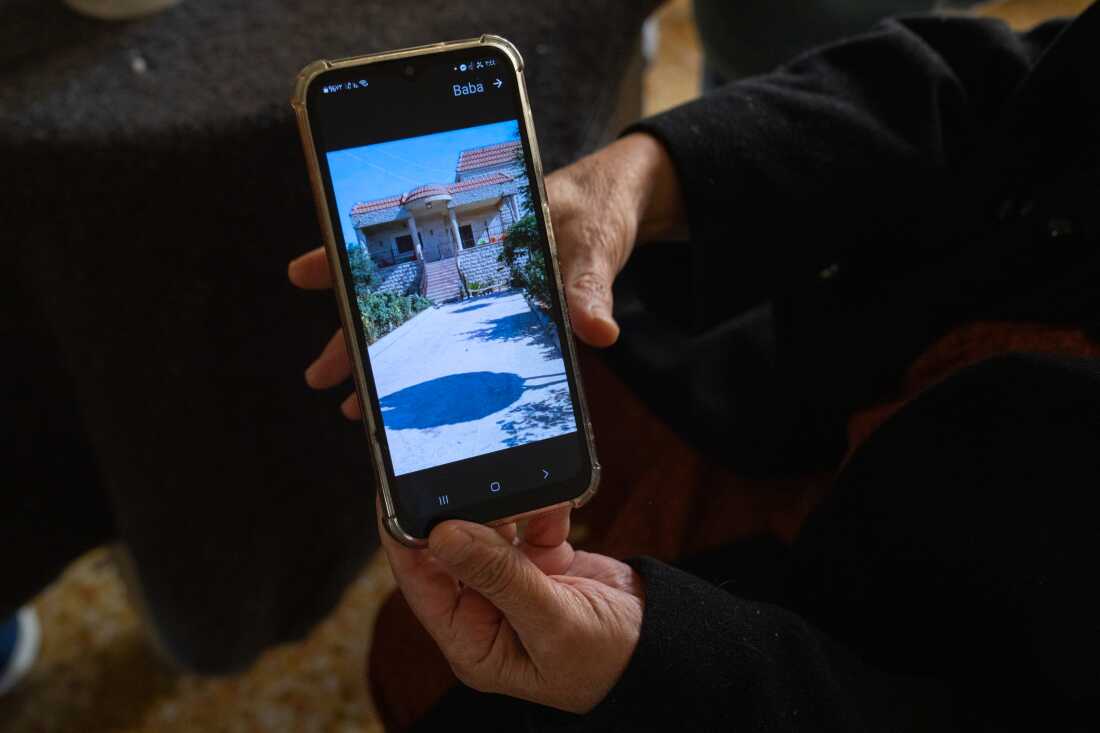 Mariam Allawiya, 60, shows a photo of her home that was destroyed just over a year ago.