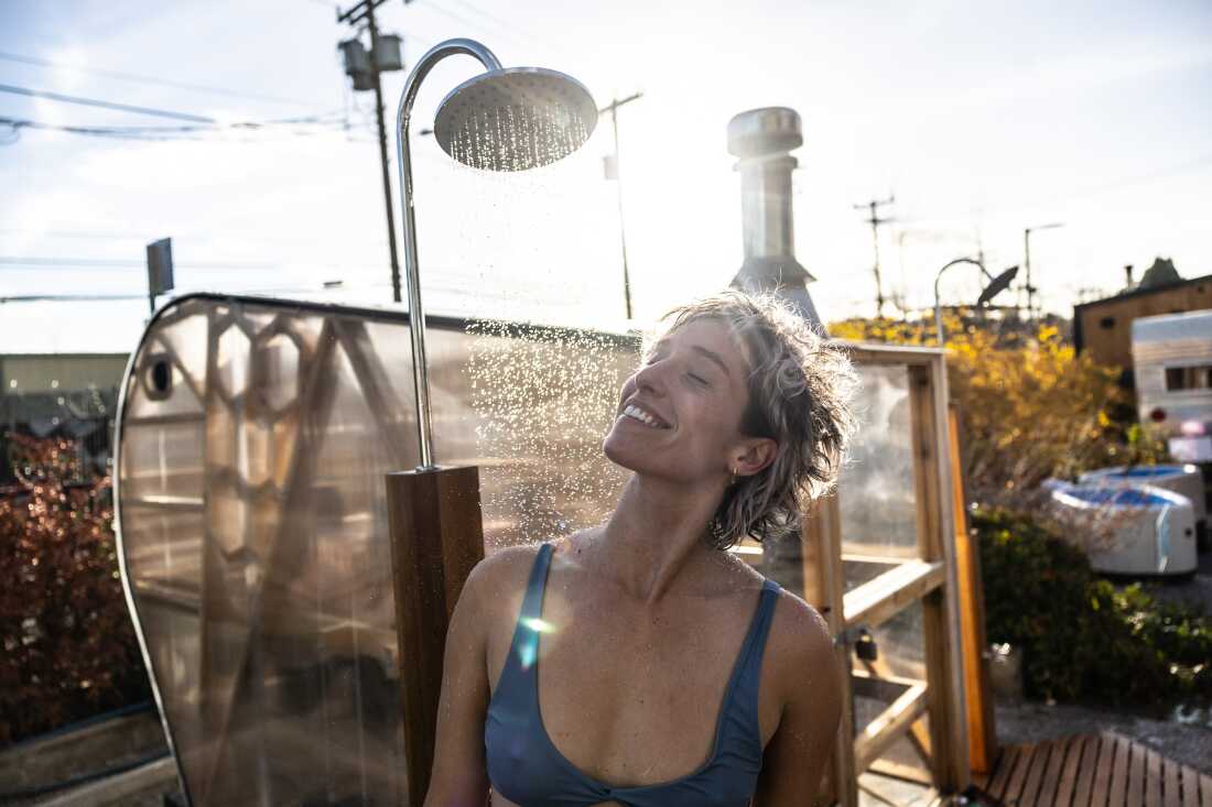 Sophia O’Connor, of Bellingham, Wash., rinses off after a sauna session, while participating in the Seattle Sauna Festival.