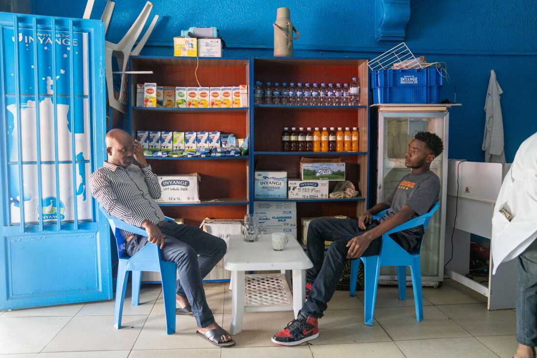 Gilly Claude Uwizeyamana (left) and Gilles Bertrand Niyomwungeri sit at milk zone drinking some milk one afternoon in June in Kigali.
