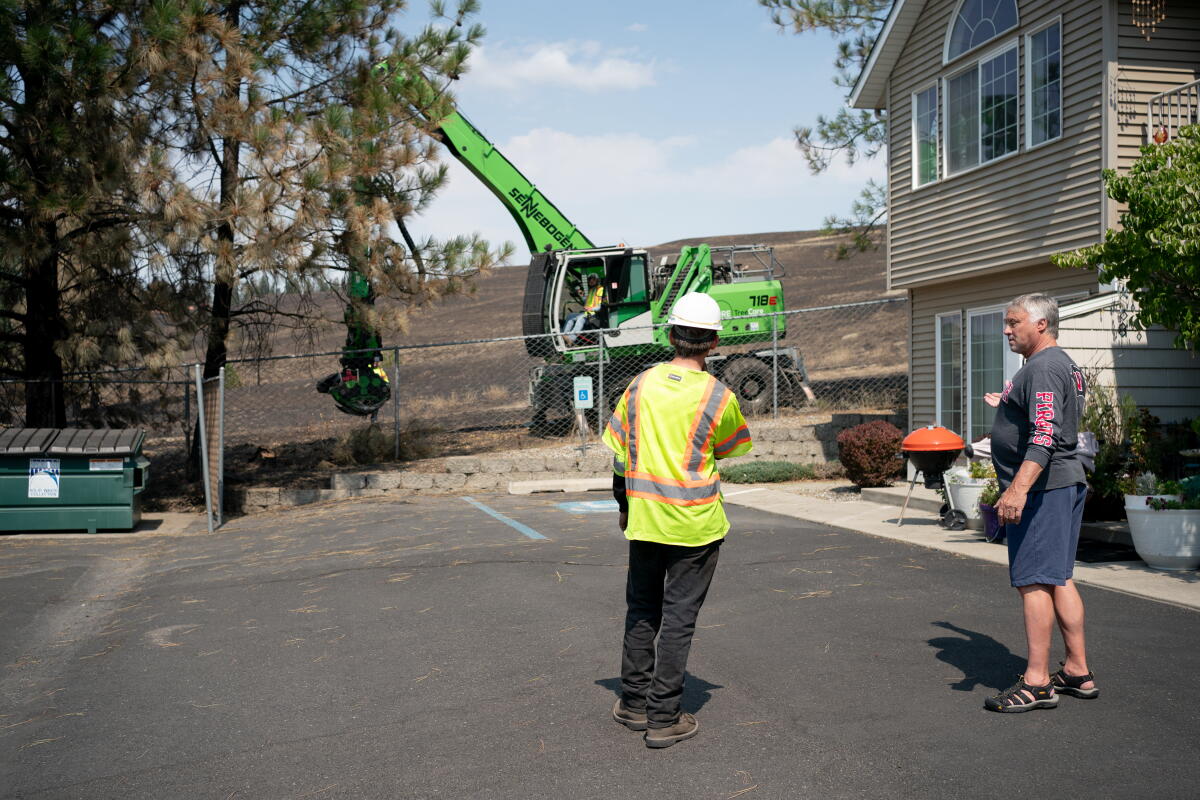 Spokane wildfire evacuees return home, but it's 'still a hazmat situation' 3 Don Simpson talks with service workers cutting down damaged trees in front of his apartment in Spokane, Wash. on August 14, 2026. During the fire, Simpson helped four residents from the Brookdale Nine Mile Nursing Facility evacuate during the Spokane Complex Fire.