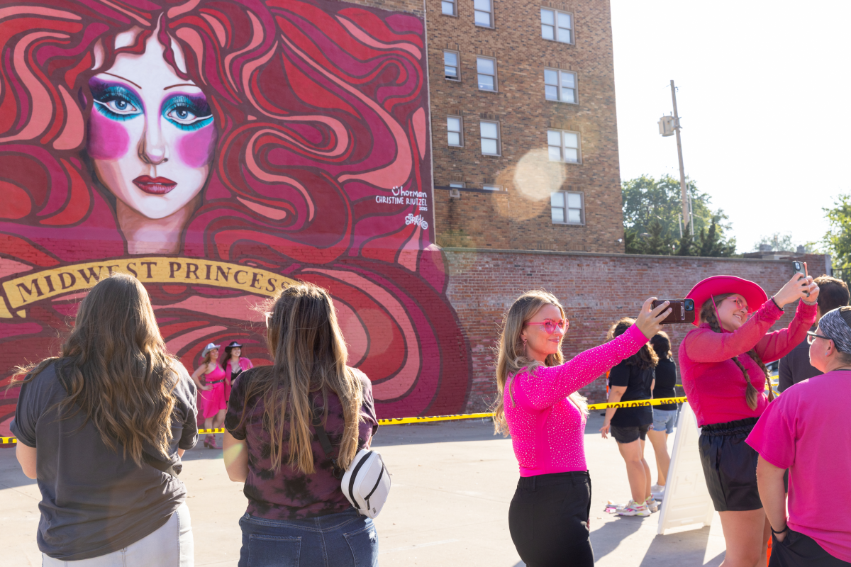 People wait in line to take a picture in front of a mural depicting Chappell Roan before her concert in Kansas City, Mo., on Friday, Oct. 3. The mural is near the city's Hamburger Mary's, known for their drag shows and where Chappell Roan saw her first drag performance.