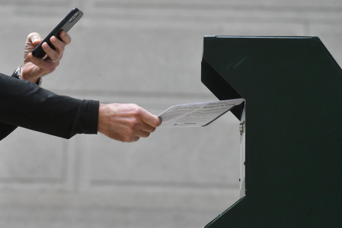 A man photographs himself depositing his ballot in an official ballot drop box in Philadelphia on Oct. 27, 2020.
