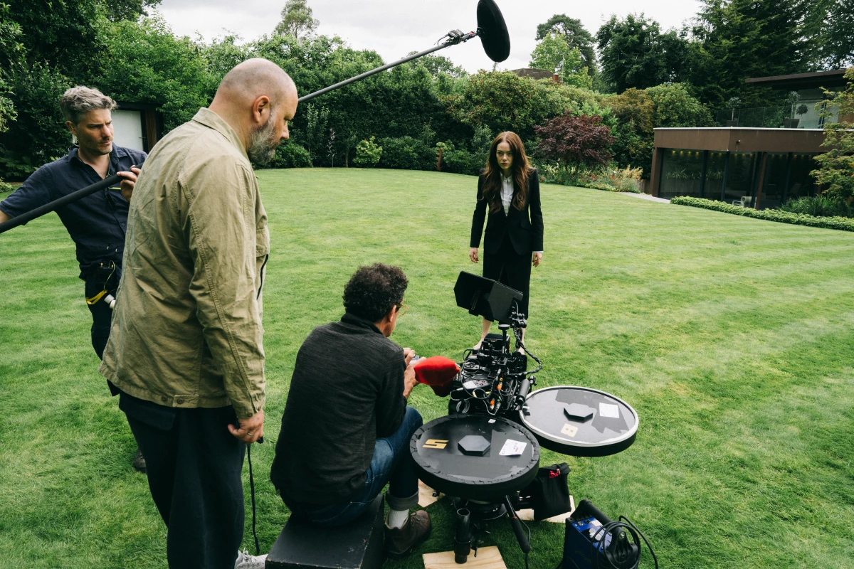 Yorgos Lanthimos, shown standing on set and looking down at the equipment, shot much of his film Bugonia on VistaVision film using a rare Wilcam 11 camera.