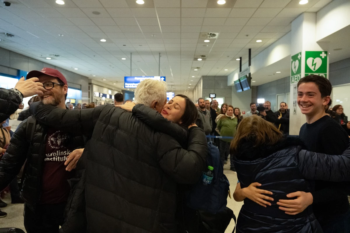 Air travelers stranded by the Iran conflict are greeted in Athens, Greece, after arriving on a charter flight from Dubai on Saturday.