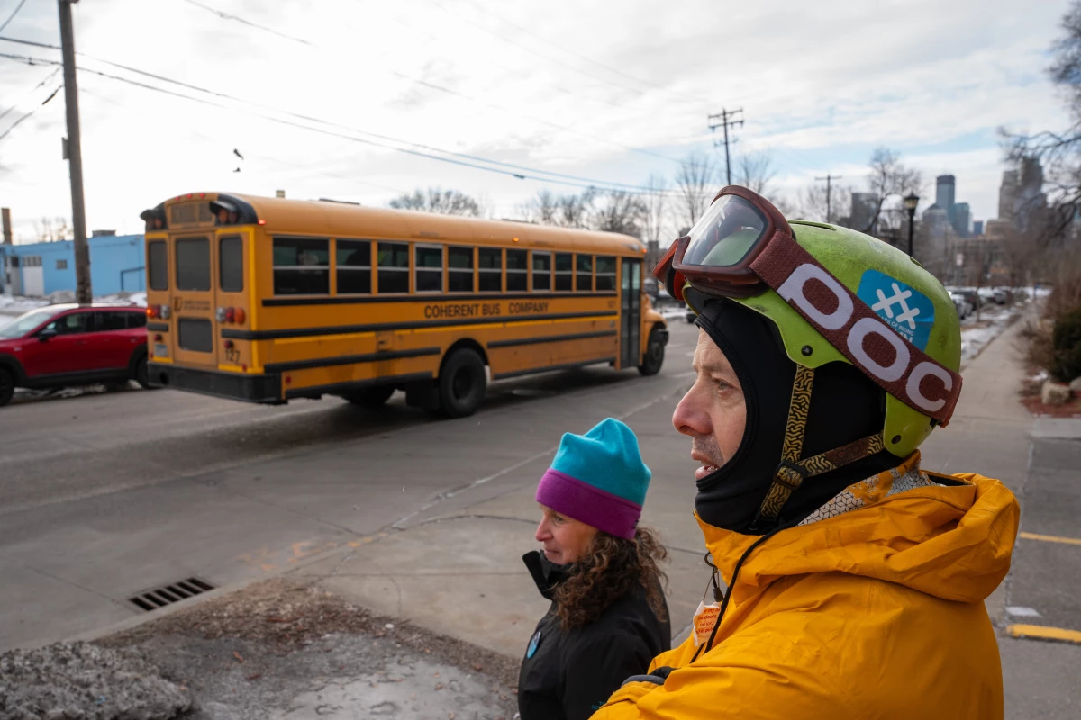 A school bus pulls away from a bus stop in Minneapolis as Brooke Magid Hart and James Umbanhowar keep watch for ICE officers. Parents and community members have been patrolling near schools all over the Twin Cities region. 'It seems like there are no stops on what ICE is going to do, they keep pushing us and pushing us,' Umbanhowar said.