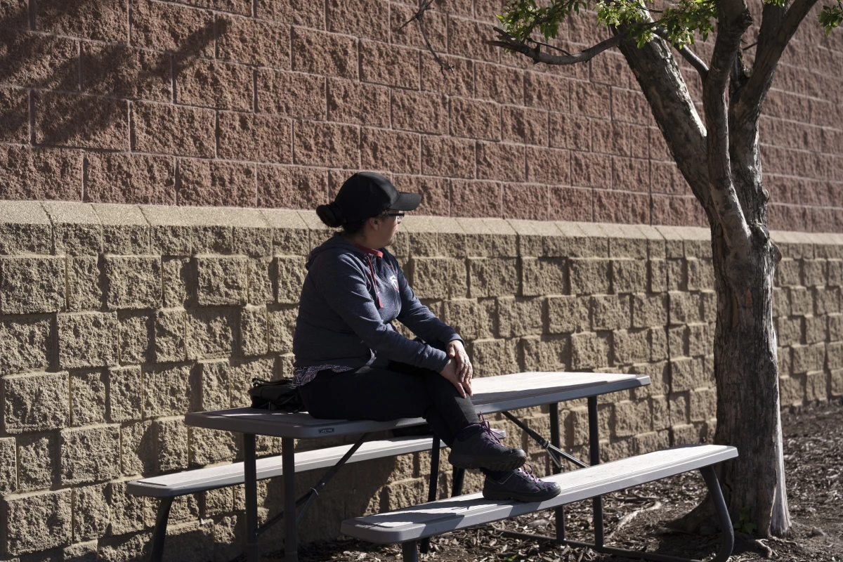 R, a day laborer from Ecuador who cleans houses for a living, waits for work outside a Home Depot in the Twin Cities, Minn. on April 22, 2026. Although she has returned to work following Operation Metro Surge, R has seen both a decline in work opportunities as well as a decrease in hourly wages being offered.