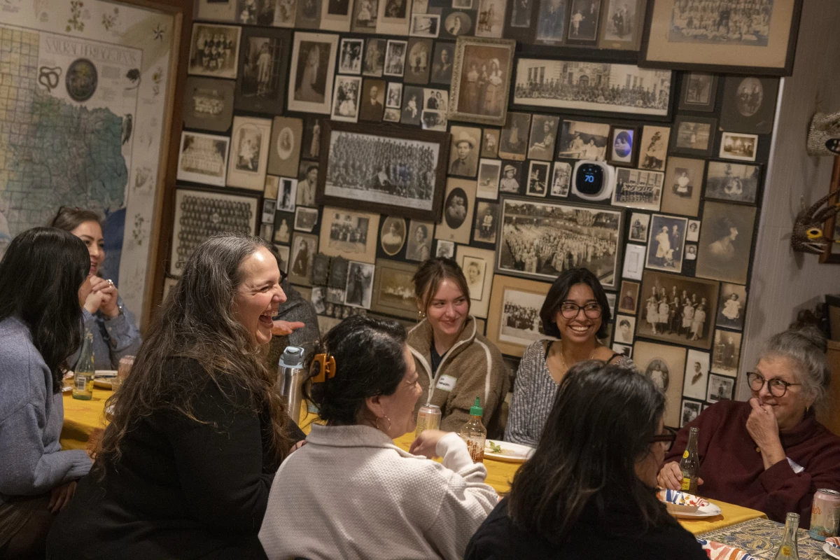 Members of Las Comadres Para Las Americas laugh during a potluck in Austin, Texas on Jan. 27. On this night the gathering takes place at the home of Lourdes Rodriguez — filled with art from the Americas, Asia and Africa. The mood is festive, warm, but also solemn, at times.