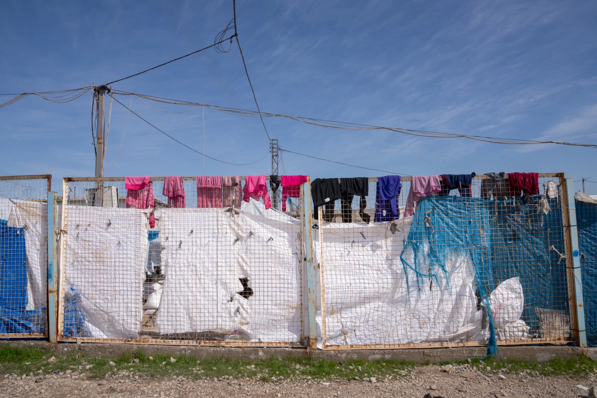 Laundry hangs on the top of a metal fence at Roj.