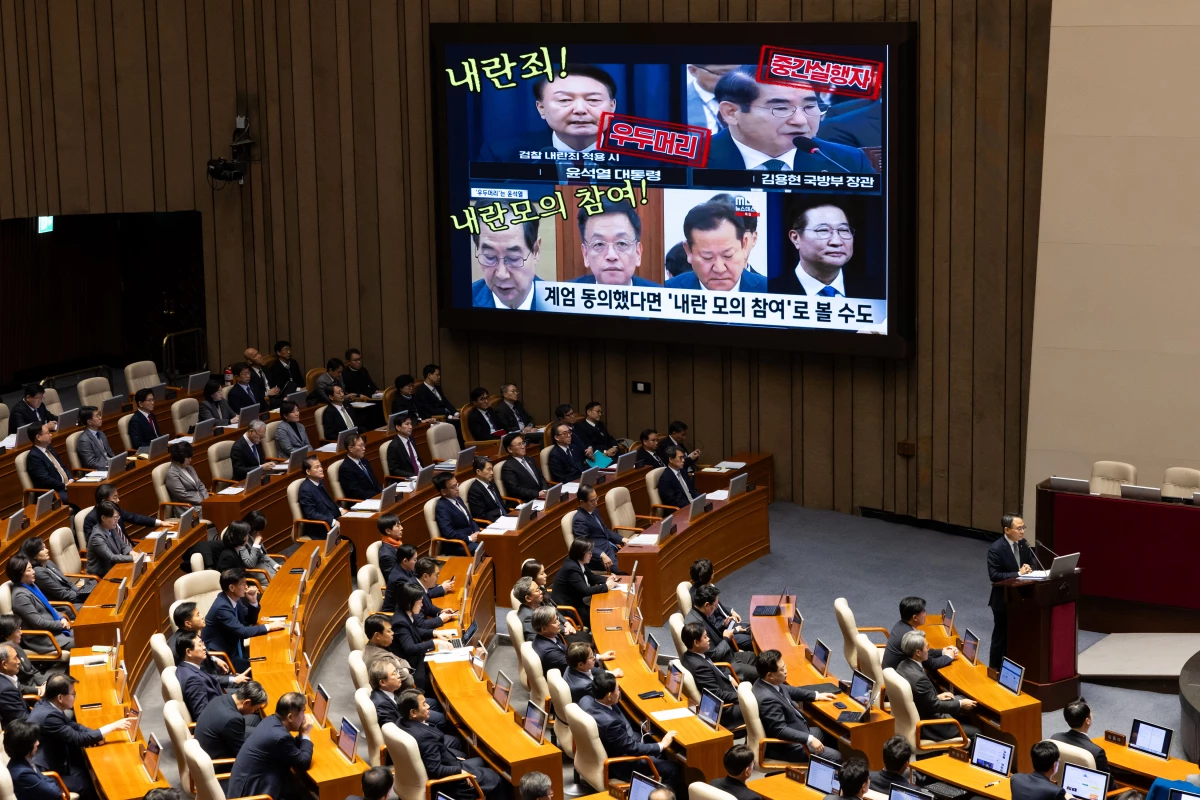 A screen displays photographs of South Korean President Yoon Suk Yeol (top left) and former and current cabinet ministers, accusing them of treason, during a plenary session at the National Assembly in Seoul, South Korea, on Wednesday. Yoon looks set to fight on rather than step down early as probes deepen into his martial law declaration and another likely impeachment bid loom.