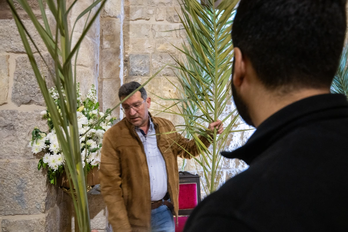 Naim Rouhaim, whose brother is the parish priest, helps to set up palms at St. Maron church, the evening before Palm Sunday.