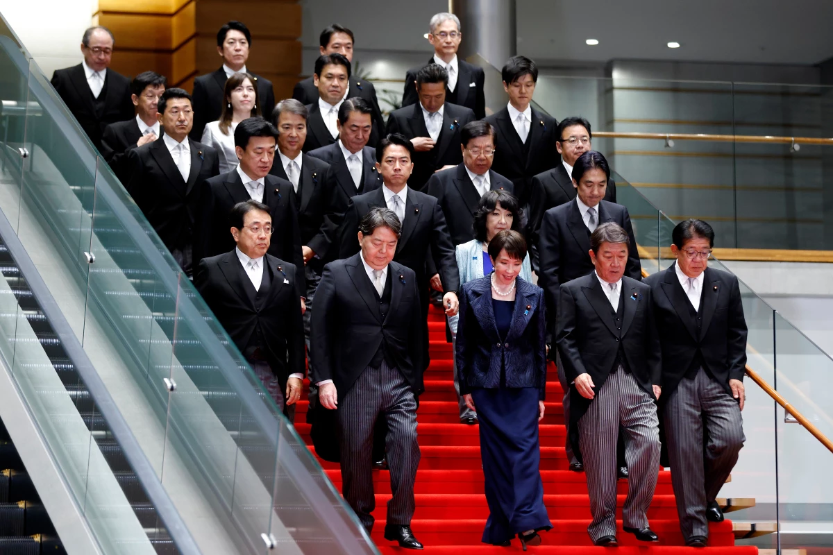 Japan's Prime Minister Sanae Takaichi poses with her new cabinet members at the prime minister's office in Tokyo on Tuesday. She appointed two female cabinet members, despite her campaign promises to elevate their representation to 'Nordic levels.'
