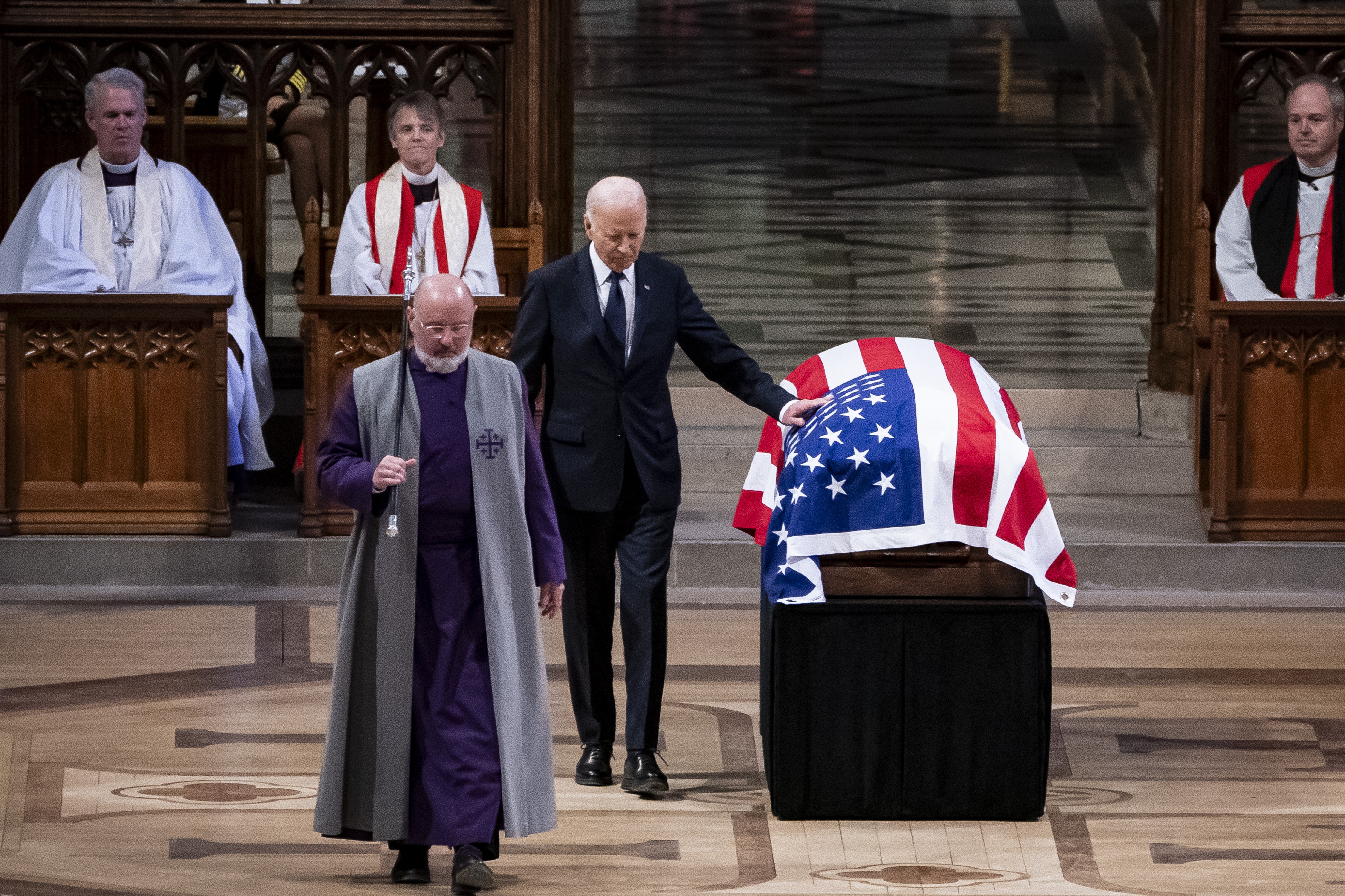 President Biden touches the casket containing former President Jimmy Carter's remains after delivering a speech during the state funeral at the Washington National Cathedral on Thursday. (Getty Images)