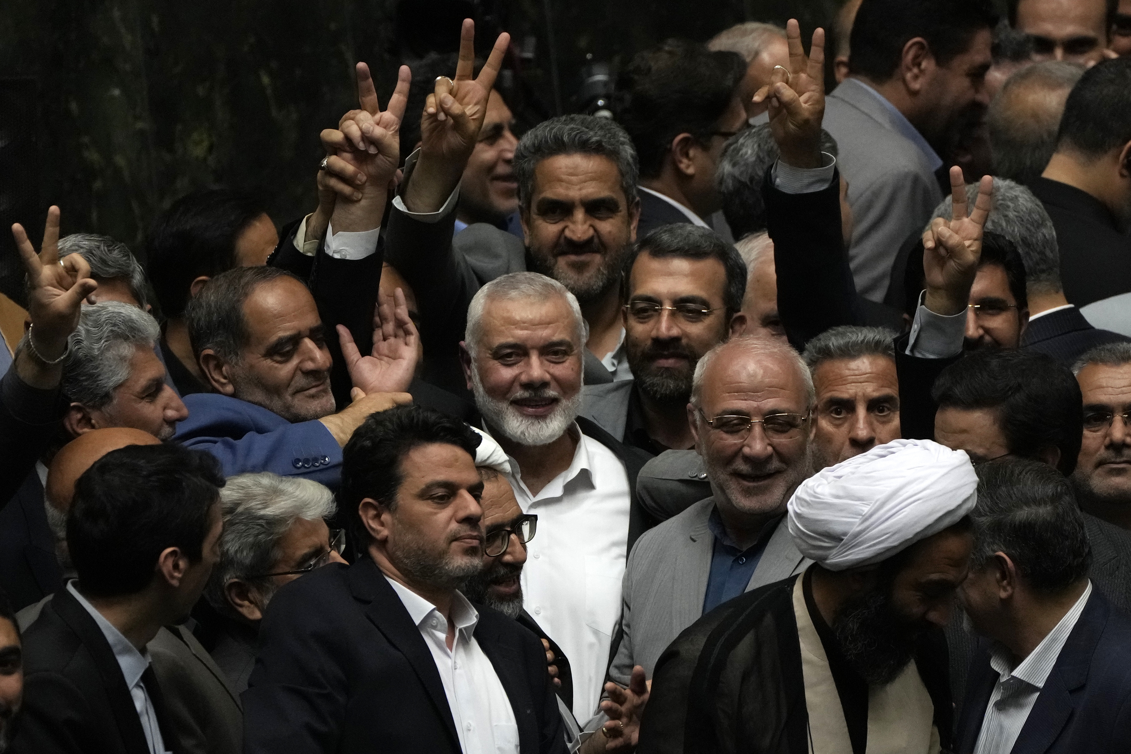 Palestinian Hamas chief Ismail Haniyeh, center, flashes a victory sign as he is surrounded by a group of Iranian lawmakers after the swearing-in ceremony of newly-elected Iranian President Masoud Pezeshkian at the parliament in Tehran, Iran, on Tuesday. (AP)