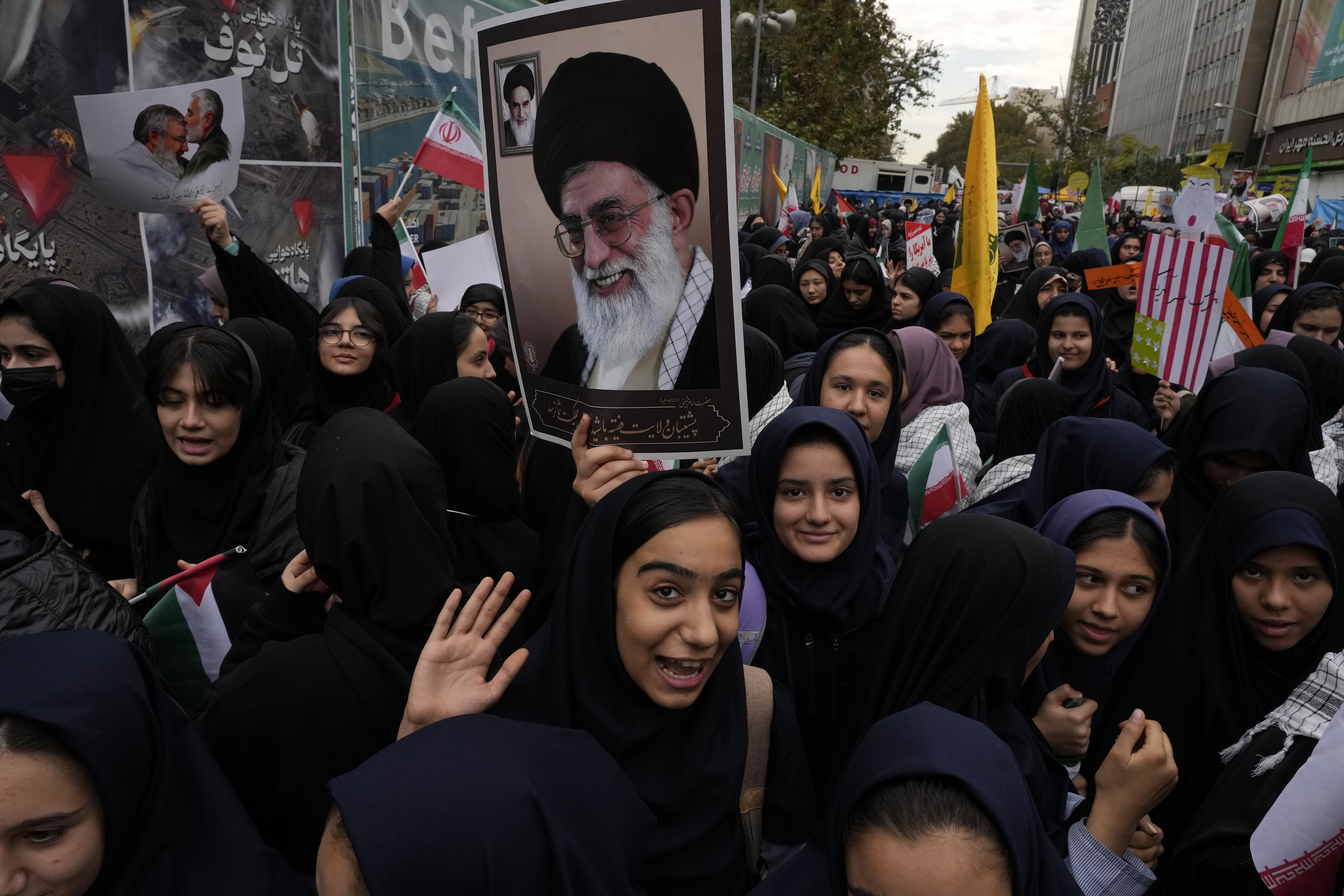 Holding a poster of the Iranian Supreme Leader Ayatollah Ali Khamenei, students attend an annual rally in front of the former U.S. Embassy in Tehran, Iran, Sunday, Nov. 3, 2024, marking the 45th anniversary of Iranian students