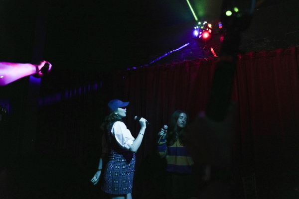 Erika Veurink (left) sings at karaoke during the after-party of her debut novel, Exit Lane in New York City.