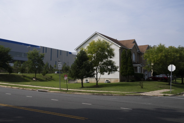 A long Vantage data center building stands behind residential buildings in Sterling, Virginia.