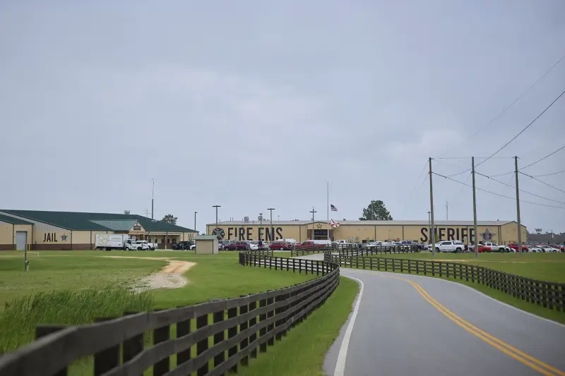 This photo from Walton County shows a compound comprising two large, low-slung buildings. The building on the left says "JAIL" on its side. The second building says "FIRE EMS" at one end and "SHERIFF" at the other end.