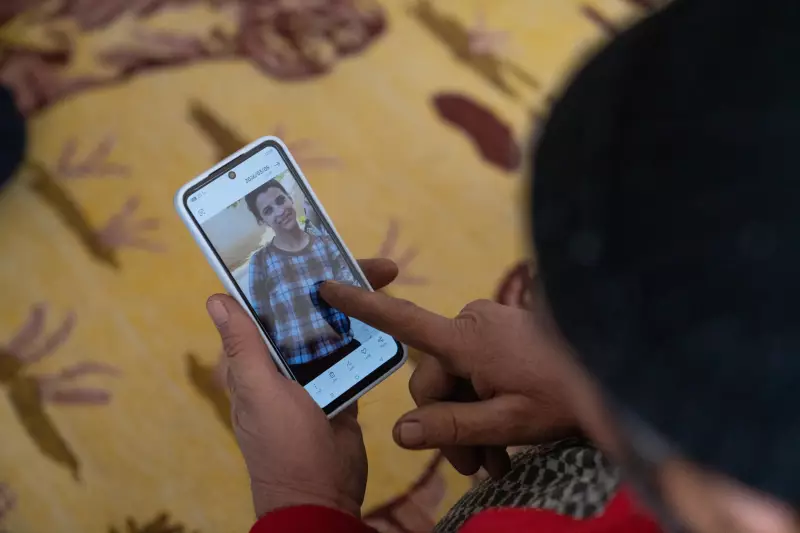 Said Mohammad Mustapha looks at pictures of his 15-year-old daughter, Zaynib, on his phone. He and his wife lost contact with Zaynib.