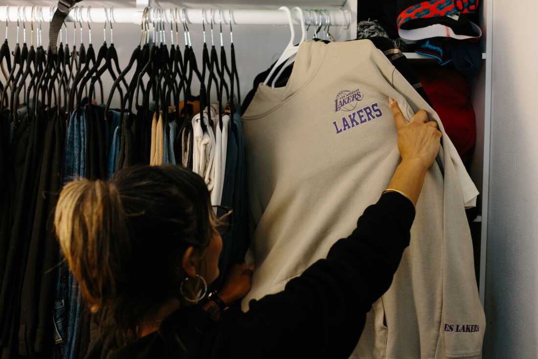 Serrato pulls out a Lakers sweatshirt from her partner's closet.