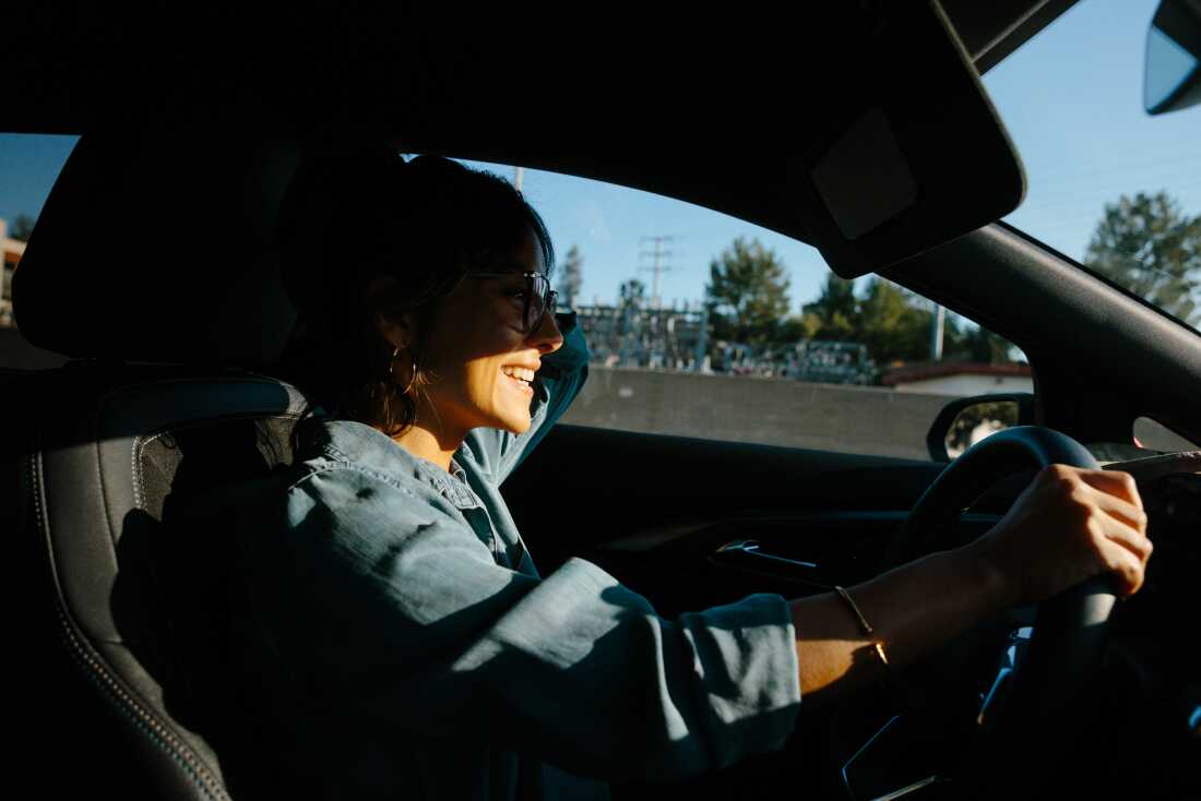 Jessica Serrato shares a light moment over the phone with her servicemember partner deployed to the Middle East while she drives her children to school in Southern California on May 6, 2026.
