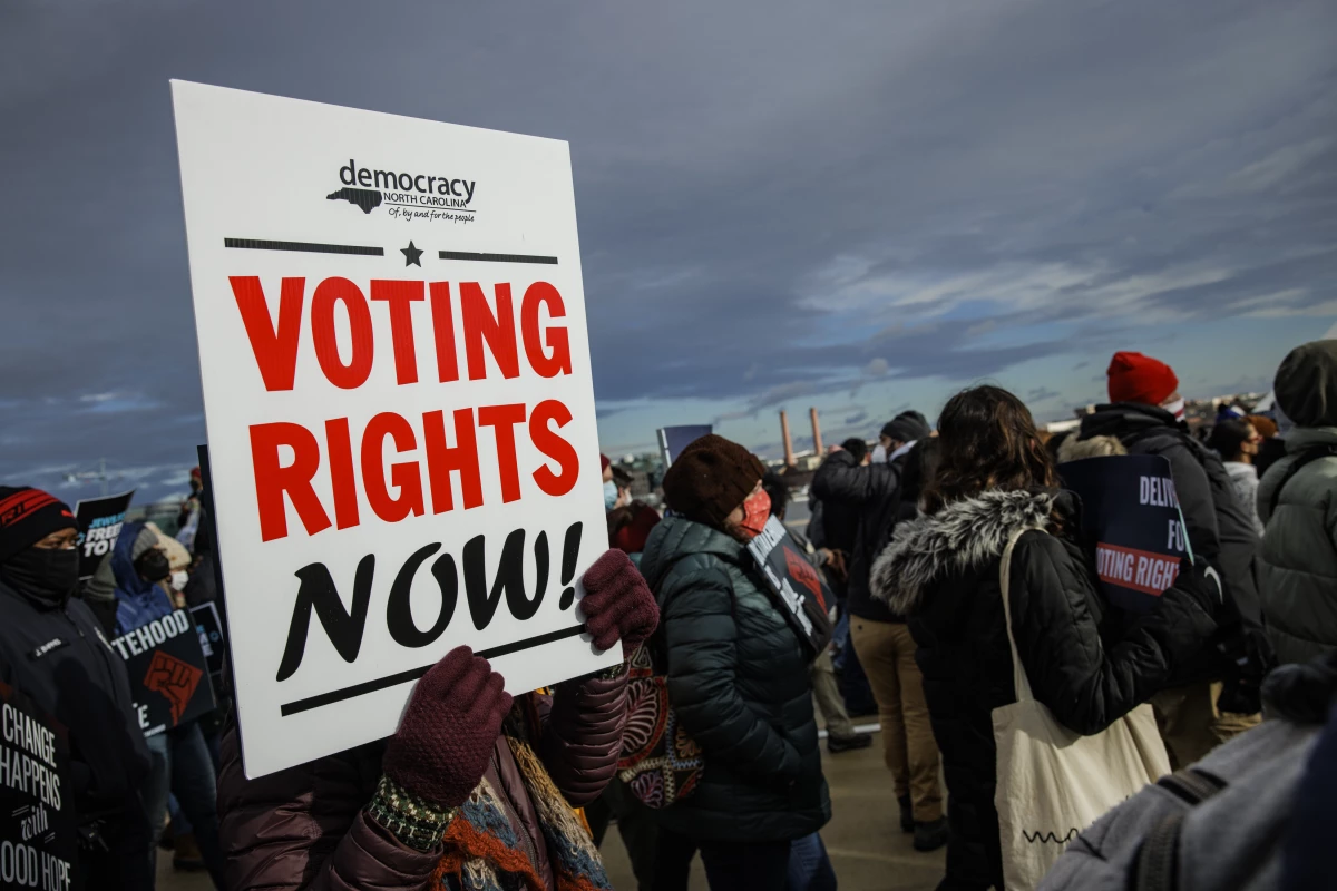 A person holds a sign that says 'VOTING RIGHTS NOW' during a peace walk in Washington, D.C., on Martin Luther King Jr. Day in 2022.
