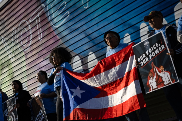 Supporters of Vice President Harris hold a Puerto Rican flag during a demonstration near the PPL Center ahead of a campaign rally with former President Donald Trump in Allentown, Pa., on Tuesday.