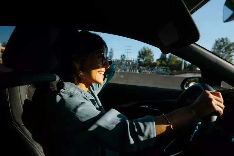 Jessica Serrato shares a light moment over the phone with her servicemember partner deployed to the Middle East while she drives her children to school in Southern California on May 6, 2026.