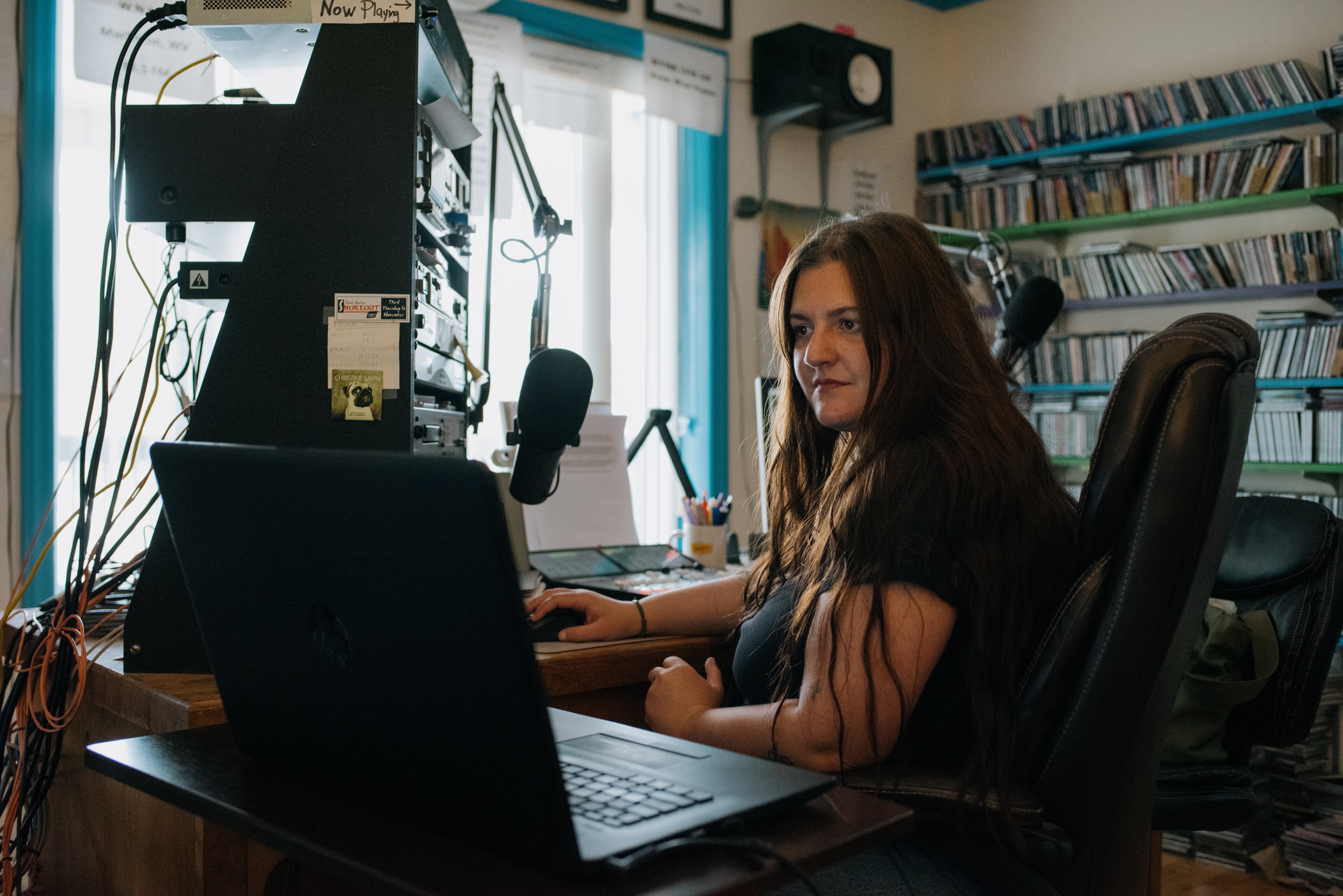 Abby DuFour, WCHG news reporter and afternoon host of the show <em>DuFour Du Jour</em>, cues up the next song in her broadcast at the station in Hot Springs, Va.