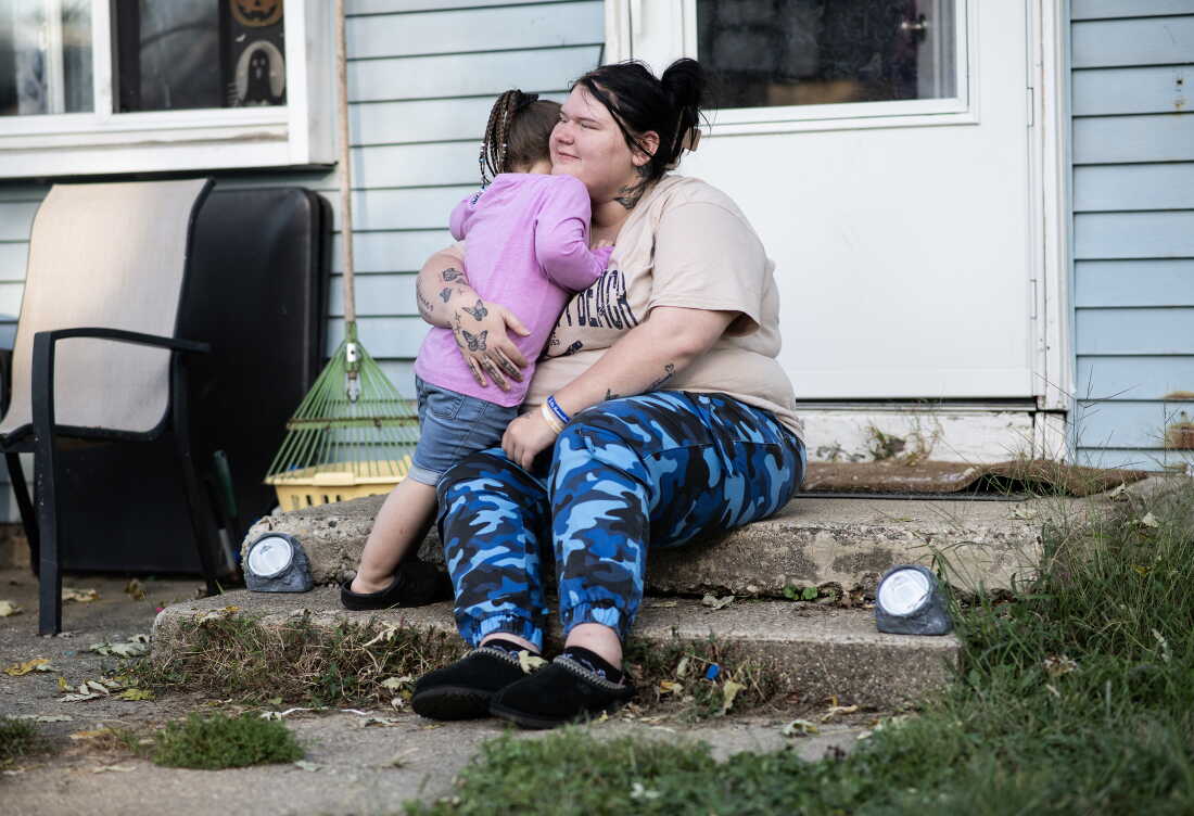 Lewis hugs her daughter, Gianna, outside their home in Indianapolis.
