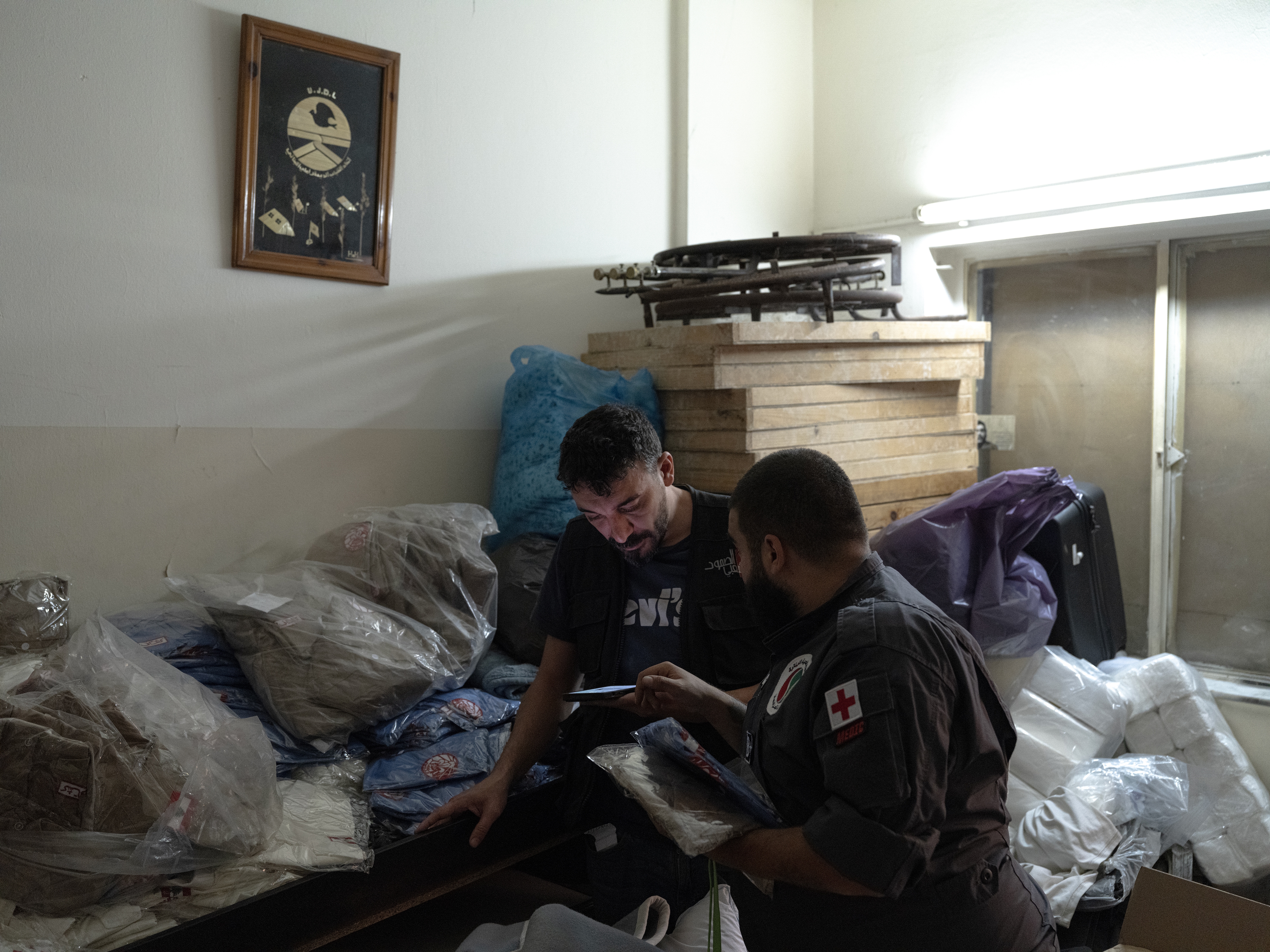 Jad Deeb, a volunteer of the Lebanese Popular Relief Association, prepares school clothes for displaced Lebanese children with one of his colleagues in their office in Beirut, Lebanon.