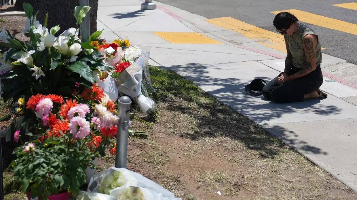 Nicole Witherow prays beside flowers placed outside the Islamic Center of San Diego on May 19.