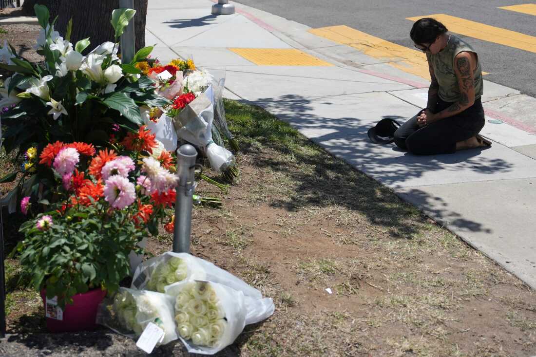 Nicole Witherow prays beside flowers placed outside of the Islamic Center of San Diego on May 19.