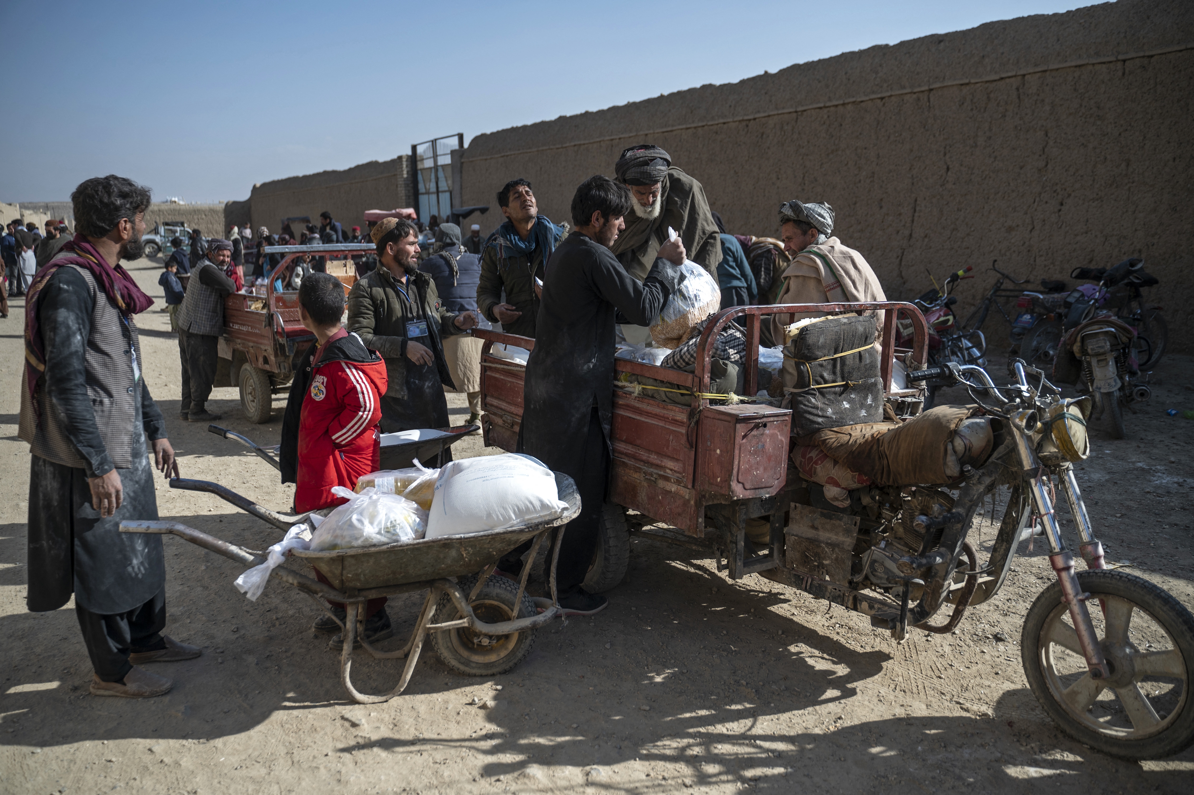 Afghan men load up food packets that were distributed as aid by the World Food Programme. Last weekend, all USAID contracts supporting humanitarian aid from WFP and other agencies in Afghanistan were canceled.