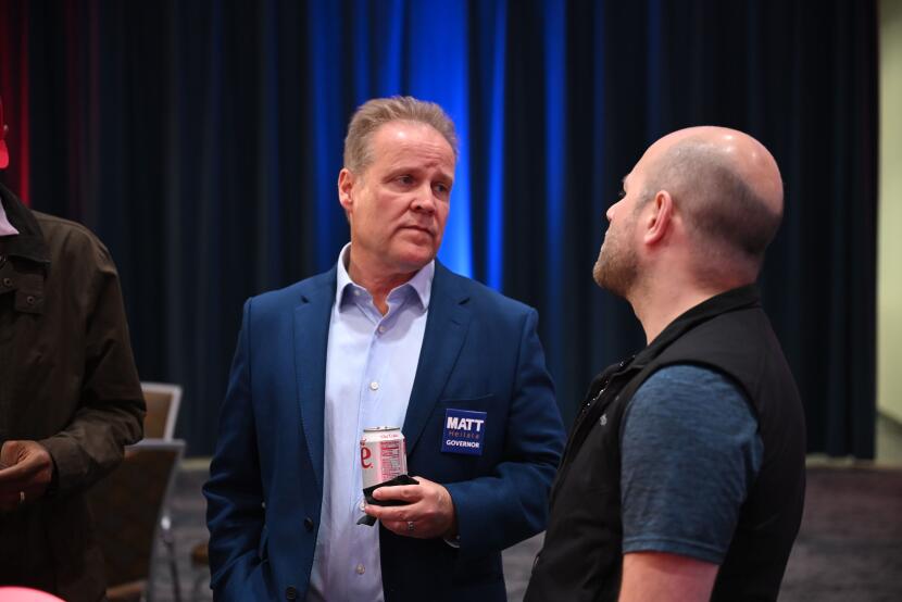 Podiatrist and Republican candidate for Gov. Matt Heilala, left, speaks with Trevor Shaw at the Alaska Landmine's watch party at the Egan Center in Anchorage on Aug. 18, 2026.