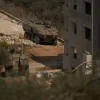 Israeli armored vehicles are seen parked outside a Palestinian building in the West Bank town of Turmus Ayya, Friday, Oct. 23, 2026. (AP Photo/Leo Correa)