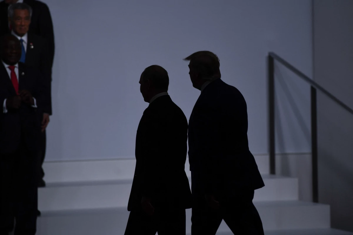 President Donald Trump (right) walks with Russia's President Vladimir Putin before taking a family photo at the G20 Summit in Osaka on June 28, 2019.
