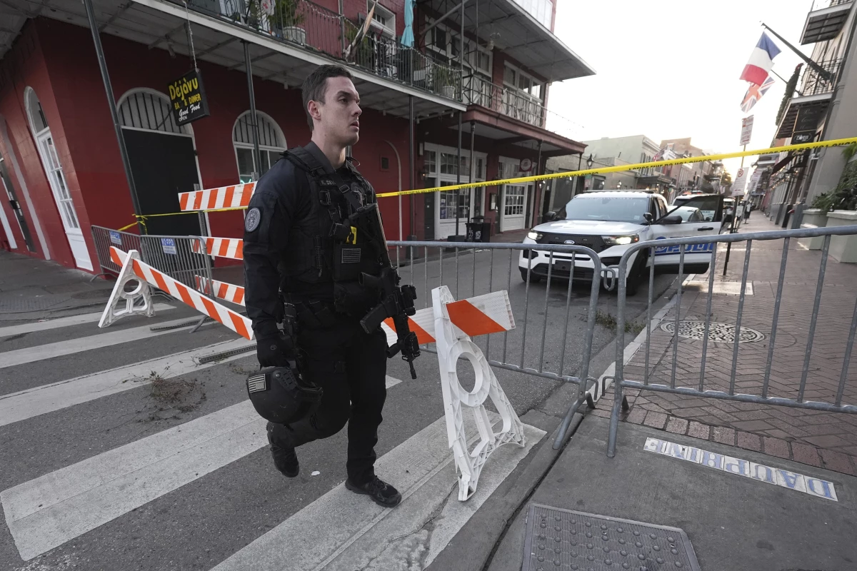 A member of the emergency services walks past a police barricade after a vehicle drove into a crowd on New Orleans' Canal and Bourbon Street.