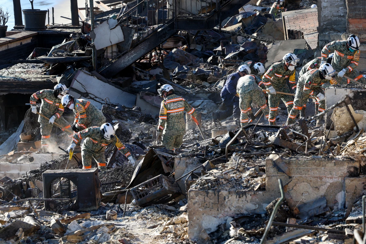 An urban search and rescue team from Mexico combs through the ruins of a beachfront house searching for victims in the aftermath of the Palisades Fire in Malibu, Calif., on Tuesday.
