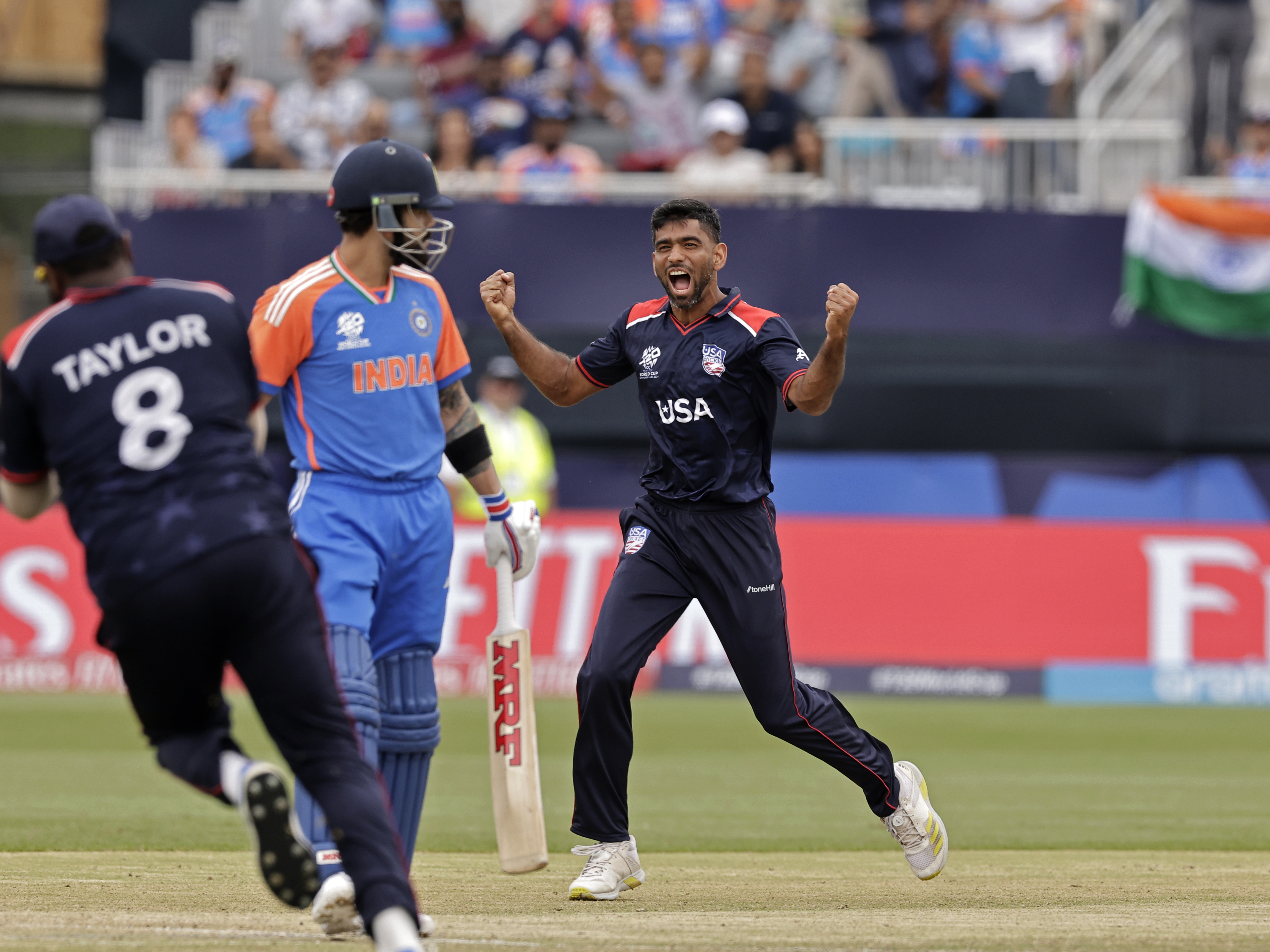 Saurabh Netravalkar, right, has become the breakout star of the U.S. national cricket team due to heroics like his dismissal of Indian superstar cricketer Virat Kohli, center, during Wednesday