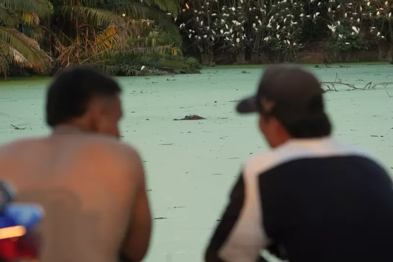 Locals relax as they watch hippos floating in a lake near Doradal, Colombia, April 23