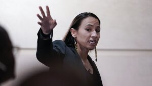 Rep. Sharice Davids, D-Kan., is shown in a midrange portrait, gesturing with one hand. She is a young woman of Native American descent. 